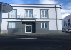 um edifício branco com uma varanda numa rua em Azores Calheta Inn T2 Frente Boa Nova em Ponta Delgada