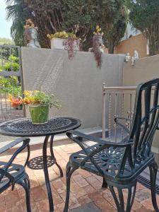 a table and chair with a potted plant on a patio at The Blue Door in Pretoria