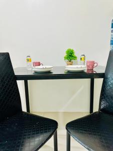uma mesa com duas cadeiras e pratos e plantas sobre ela em Sea Residences by Jan & Val Alano em Manila