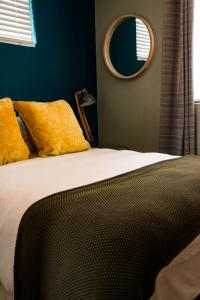 a bedroom with a bed with a mirror on the wall at 16 On Antrim in Hermanus