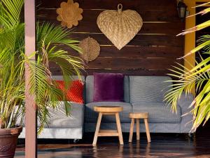 a couch and two stools in a room with plants at Jan Kok Lodges in Willibrordus