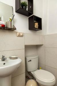 a bathroom with a white toilet and a sink at Finca San Antonio De Shudal in Cajamarca
