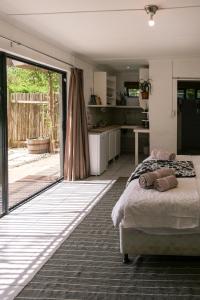 a bedroom with a bed and a large sliding glass door at Canary Cottage in Greyton