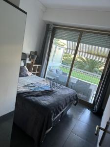 - une chambre avec un lit et une grande fenêtre dans l'établissement Bel appartement proche de la mer, à Nice