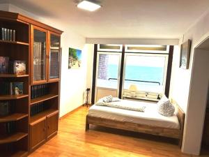 a bedroom with a bed and a large window at Ferienwohnung im Strandhotel in Wyk auf Föhr