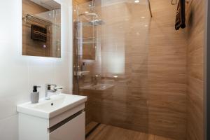uma casa de banho com um lavatório branco e um chuveiro em K&J Loft em Tbilisi