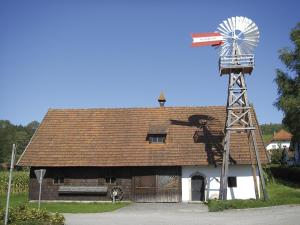 eine alte Scheune mit einer Windmühle darüber in der Unterkunft Osternacherhof in Osternach