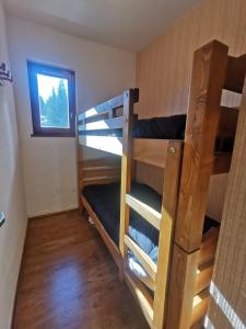 a room with two bunk beds and a window at Appartement 4 personnes au pied des pistes in Les Déserts