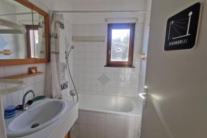 ein Badezimmer mit einem Waschbecken, einer Badewanne, einem Waschbecken und einem Spiegel in der Unterkunft Appartement 4 personnes au pied des pistes in Les Déserts
