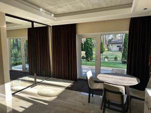 a dining room with a table and chairs and windows at Park-Hotel Tihiy Les in Prokhorovka