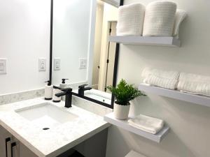 a white bathroom with a sink and a mirror at Modern and New house near PNE with Big Garden and Free Parking in Vancouver