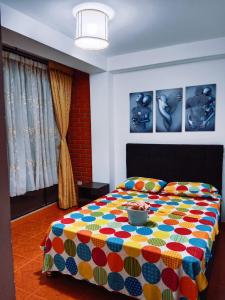 Un dormitorio con una cama colorida con un tazón. en Confort Putumayo, en Mocoa