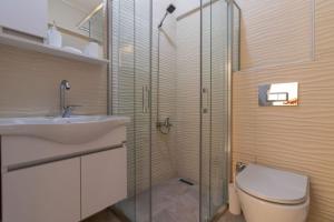 y baño con ducha, aseo y lavamanos. en Cozy & Complete 1BR Retreat w/ Balcony, en Estambul