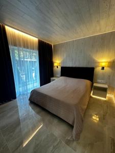 sypialnia z łóżkiem i dużym oknem w obiekcie Park-Hotel Tihiy Les w mieście Prokhorovka
