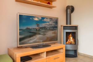 een televisie naast een open haard bij Ferienhaus Sunshine in Korswandt