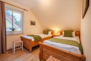 twee eenpersoonsbedden in een kamer met een raam bij Ferienhaus Sunshine in Korswandt
