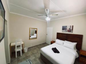 a bedroom with a bed and a ceiling fan at Comfort Home Guest House in East London