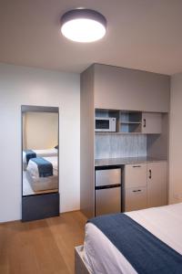 a small bedroom with a bed and a mirror at ESHEL SUITES PANAMA in Panama City