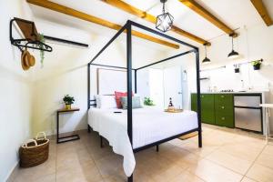 Un dormitorio con una cama con dosel en una habitación. en Catania 2 Suite W/private pool,W/heater , WIFI., en Aguadilla
