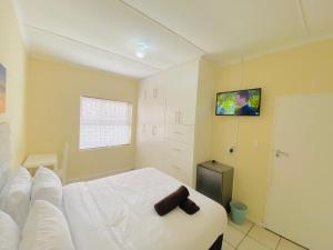 a bedroom with a bed and a tv on the wall at Comfort Home Guest House in East London