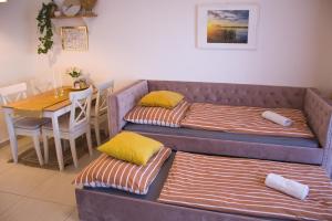 two beds in a room with a table and a dining room at Duplex apartmán Pálava in Dolní Dunajovice