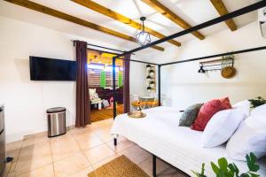 een slaapkamer met een wit bed in een kamer bij Catania 2 Suite W/private pool,W/heater , WIFI. in Aguadilla