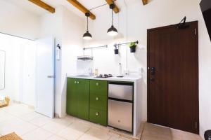 una cocina con armarios verdes y una puerta marrón en Catania 2 Suite W/private pool,W/heater , WIFI., en Aguadilla