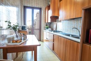 a kitchen with wooden cabinets and a table with a plate of food at I Host Apartment - Sant'Agostino 7 in Milan