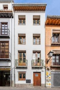 a tall white building with windows and balconies at Alto house edificio completo in Granada