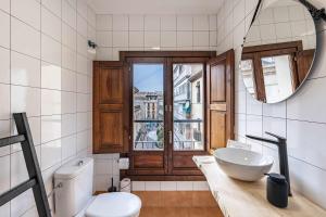a bathroom with a sink and a toilet and a mirror at Alto house edificio completo in Granada