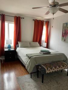 1 dormitorio con 1 cama con cortinas rojas y ventilador en Beautiful 2BR unit in the heart of K-Town, en Los Ángeles