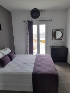a bedroom with a large bed and a window at Romantic House Sea View Adults only in Ios Chora