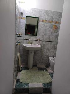 een badkamer met een wastafel, een toilet en een spiegel bij Résidence Lennards 2 in Grand Baie