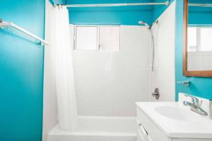 een badkamer met blauwe muren, een wastafel en een douche bij Delightful 1BR home in the Heart of K-Town in Los Angeles