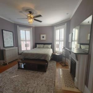 een slaapkamer met een bed en een plafondventilator bij Historic Escape in Mansion Row - Sleeps 12! in New Albany