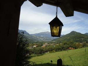 a light hanging from a house with a view of mountains at L'Eterlou Chambres d'Hote in Albertville