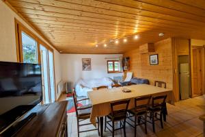 a dining room and living room with a table and chairs at Spacieux appartement au centre de la station in Les Déserts