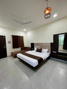 1 dormitorio con 1 cama grande en una habitación en Tekri Farms and Retreat, en Ujjain