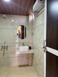 烏賈因的住宿－Tekri Farms and Retreat，一间带水槽和镜子的浴室