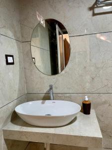 a white sink in a bathroom with a mirror at Tekri Farms and Retreat in Ujjain