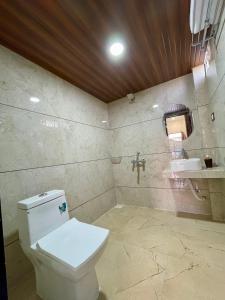 a bathroom with a toilet and a sink at Tekri Farms and Retreat in Ujjain