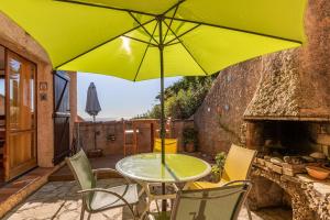 een tafel en stoelen met een gele parasol op een patio bij Bastidon Avec Terrasse Vue Mer in Carqueiranne