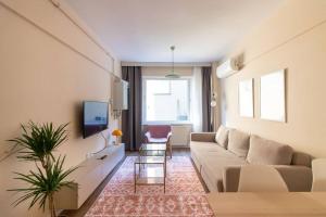 ein Wohnzimmer mit einem Sofa und einem TV in der Unterkunft Cosmopolitan & Stylish 1BR Apartment/Central Şişli in Istanbul