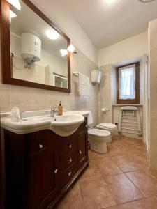 a bathroom with a sink and a toilet and a mirror at Locanda Settecamini in Campello sul Clitunno