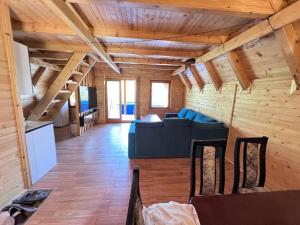 una sala de estar con sofá azul y techos de madera. en Peace of mind, en Visoko