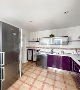 a kitchen with purple cabinets and a stainless steel refrigerator at Villa Emilia by Best Holidays Fuerteventura in Corralejo