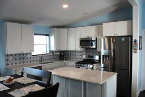 a kitchen with white cabinets and a black refrigerator at Tropical Cottages in Marathon