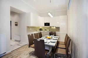 uma cozinha e sala de jantar com mesa e cadeiras em Celebration Flat by Ruterra em Praga