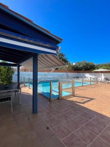 un patio con dosel azul y una piscina en Villa Emilia by Best Holidays Fuerteventura en Corralejo