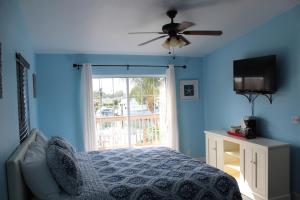 sypialnia z łóżkiem i wentylatorem sufitowym w obiekcie Tropical Cottages w mieście Marathon